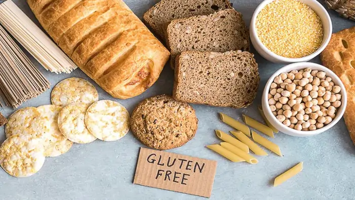 gluten-free food assortment with bread, pasta, crackers, chickpeas, and gluten free sign